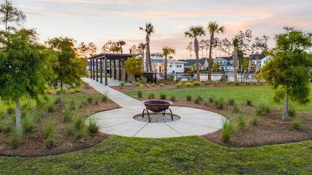 surrounding community featuring a lawn, a residential view, fence, and a fire pit