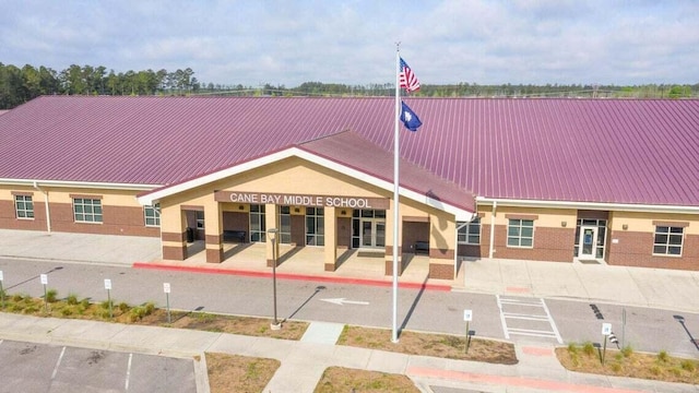 exterior space featuring brick siding and metal roof