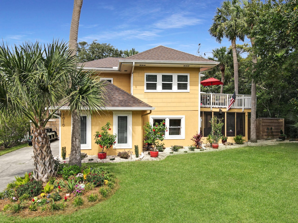 view of front of house with a front yard and a deck