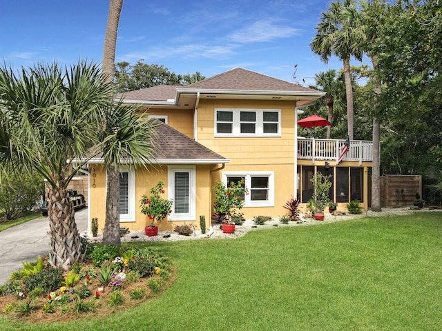 view of front of house with a front yard and a deck