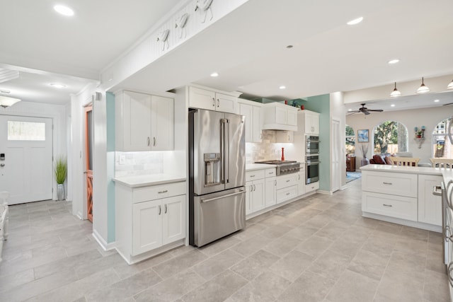 kitchen featuring stainless steel appliances, white cabinets, decorative backsplash, and ceiling fan