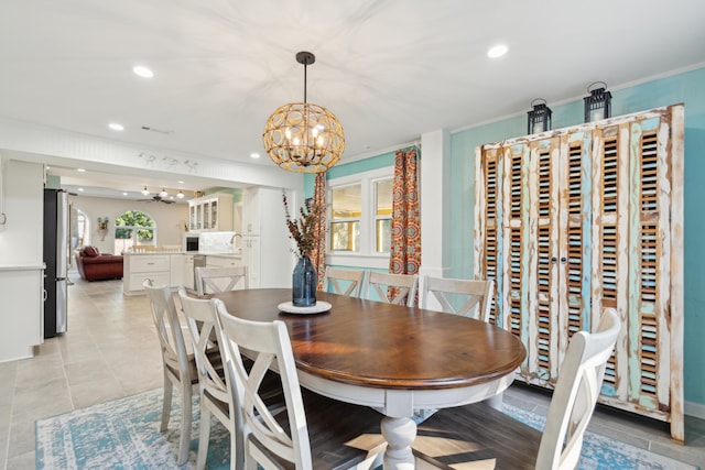 dining area featuring an inviting chandelier, crown molding, and light tile patterned floors