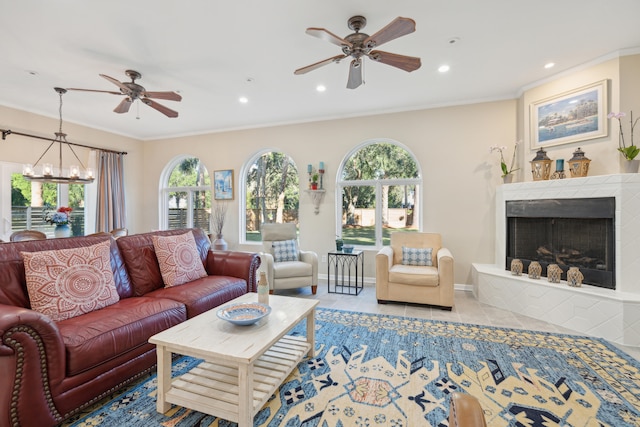 living room with ceiling fan with notable chandelier, crown molding, and light tile patterned floors