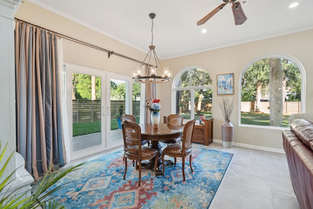 tiled dining area featuring ceiling fan with notable chandelier, ornamental molding, and a healthy amount of sunlight