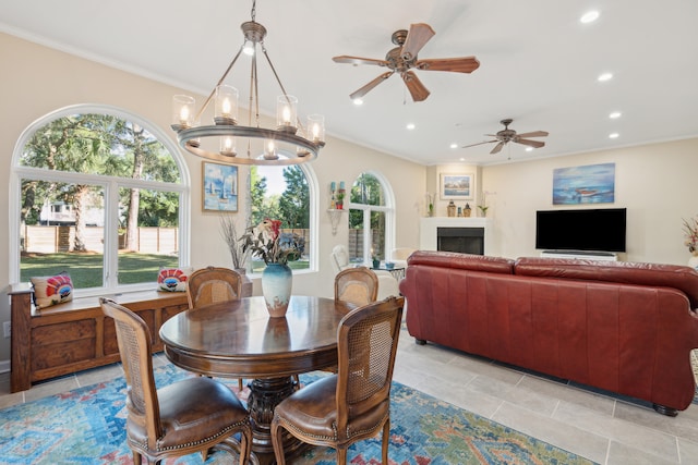 dining room featuring ceiling fan with notable chandelier, plenty of natural light, and ornamental molding