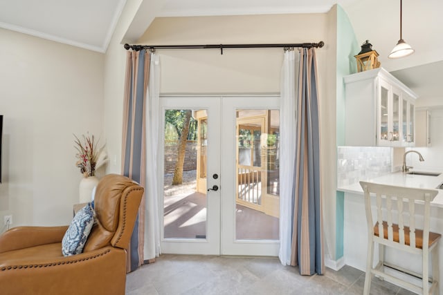 doorway featuring crown molding, vaulted ceiling, sink, french doors, and light tile patterned floors