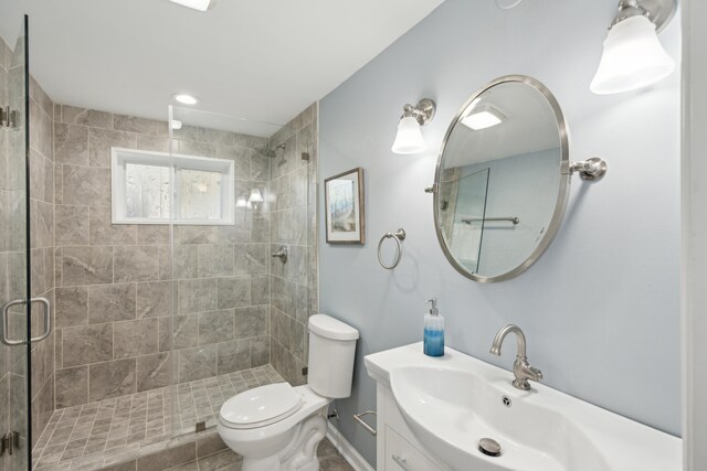 bathroom featuring vanity, walk in shower, and toilet