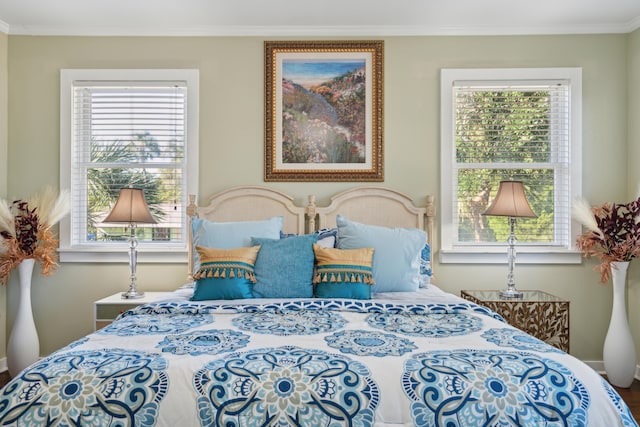 bedroom with ornamental molding and multiple windows