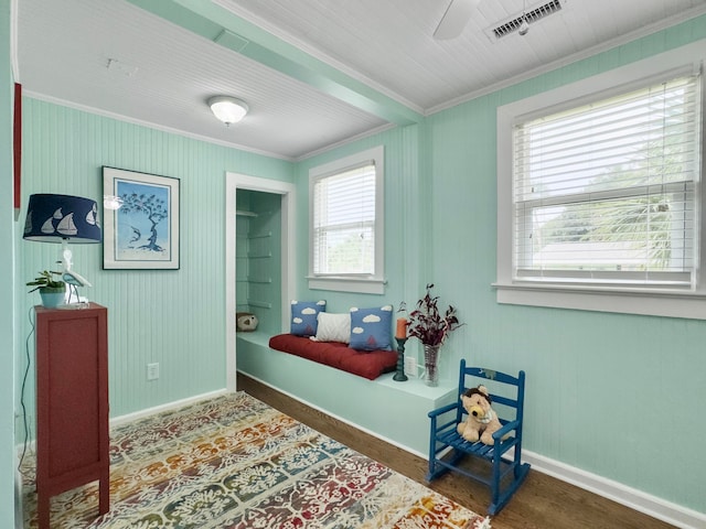 interior space with ornamental molding, a wealth of natural light, and hardwood / wood-style floors