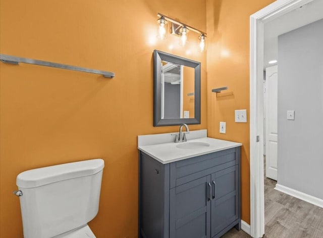 bathroom featuring vanity, hardwood / wood-style flooring, and toilet