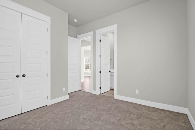 unfurnished bedroom featuring light carpet and a closet