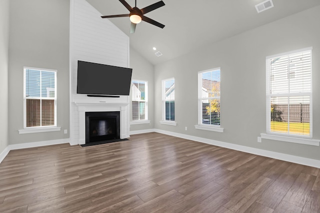 unfurnished living room featuring hardwood / wood-style floors, ceiling fan, a large fireplace, and high vaulted ceiling