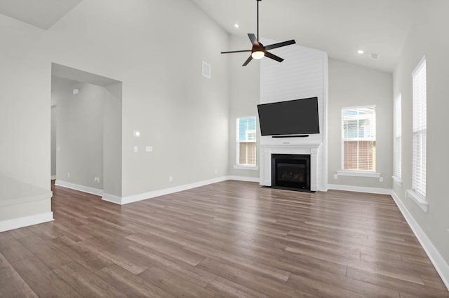 unfurnished living room featuring hardwood / wood-style flooring, high vaulted ceiling, and a wealth of natural light