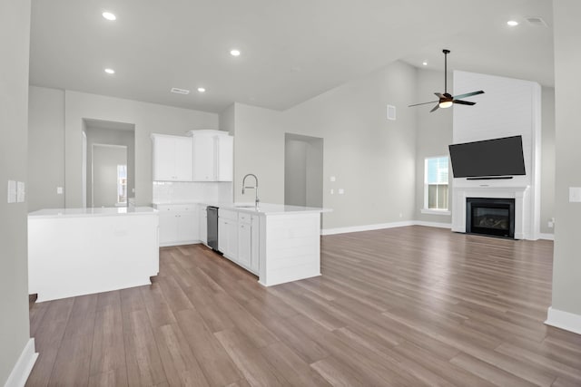 kitchen with ceiling fan, white cabinets, light hardwood / wood-style floors, and high vaulted ceiling