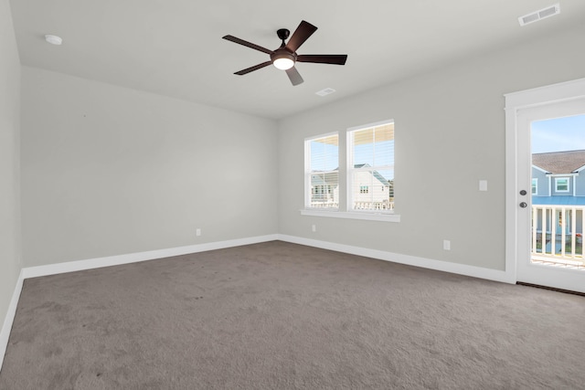 carpeted spare room with ceiling fan and plenty of natural light