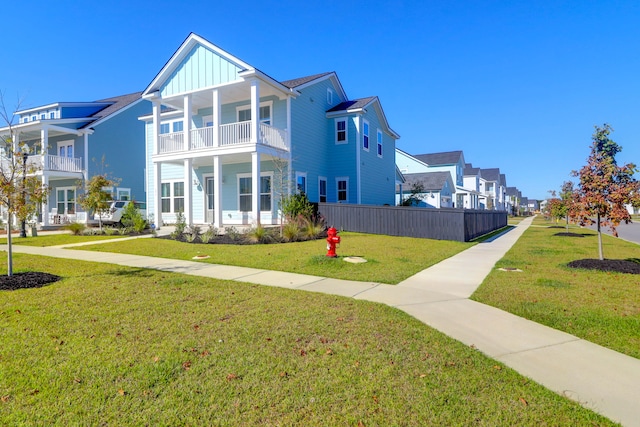 view of front facade with a balcony and a front yard