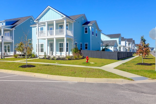 view of front facade featuring a balcony and a front lawn