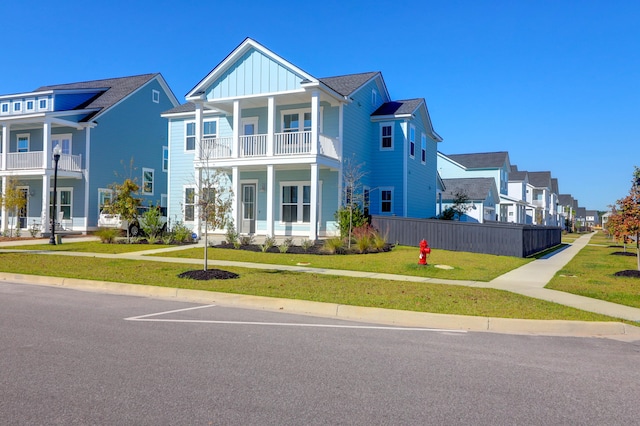 view of front of home featuring a balcony and a front lawn