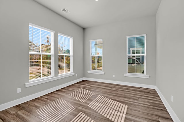 spare room with hardwood / wood-style floors and a healthy amount of sunlight