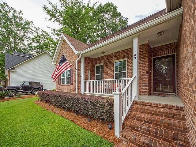 property entrance featuring a porch and a lawn