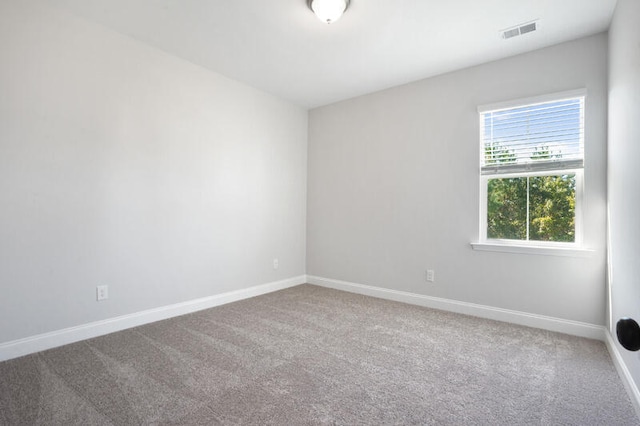 carpeted spare room with visible vents and baseboards