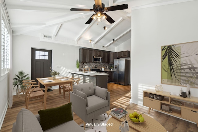 living room with ceiling fan, hardwood / wood-style floors, and lofted ceiling with beams