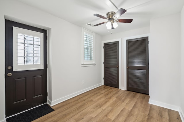 foyer entrance with ceiling fan and light hardwood / wood-style floors