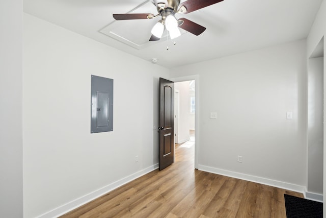 unfurnished room with electric panel, light hardwood / wood-style flooring, and ceiling fan