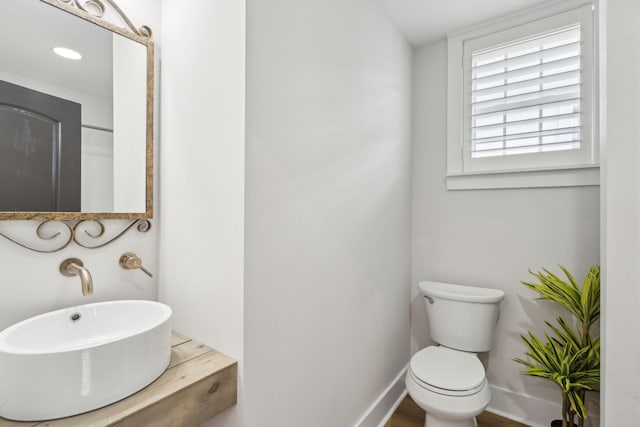 bathroom with hardwood / wood-style floors, toilet, and sink