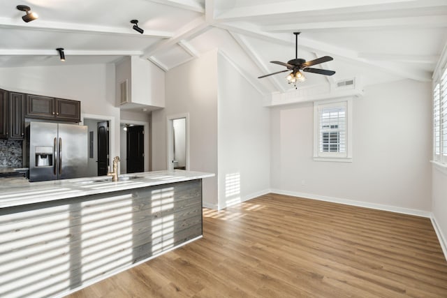 kitchen with beam ceiling, stainless steel fridge with ice dispenser, sink, and ceiling fan