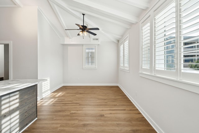 interior space featuring light wood-type flooring, lofted ceiling with beams, and ceiling fan