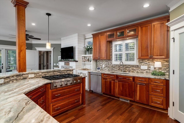 kitchen with ceiling fan, sink, light stone counters, decorative light fixtures, and appliances with stainless steel finishes