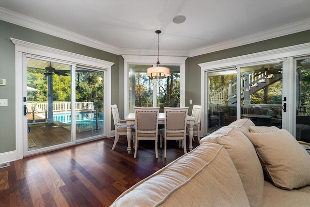 dining space featuring dark hardwood / wood-style flooring, a chandelier, and ornamental molding