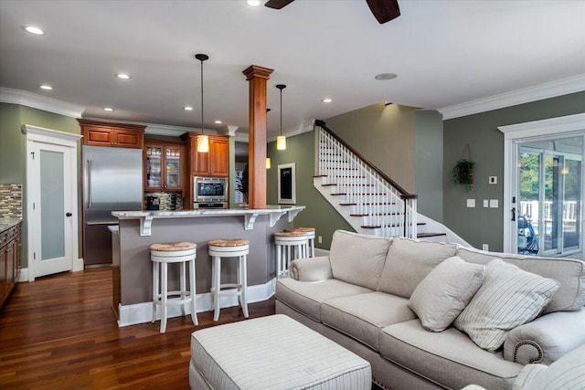 living room with dark hardwood / wood-style floors, ceiling fan, and ornamental molding