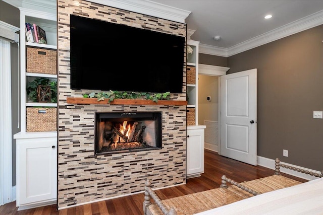 living room featuring a tile fireplace, dark wood-type flooring, and ornamental molding