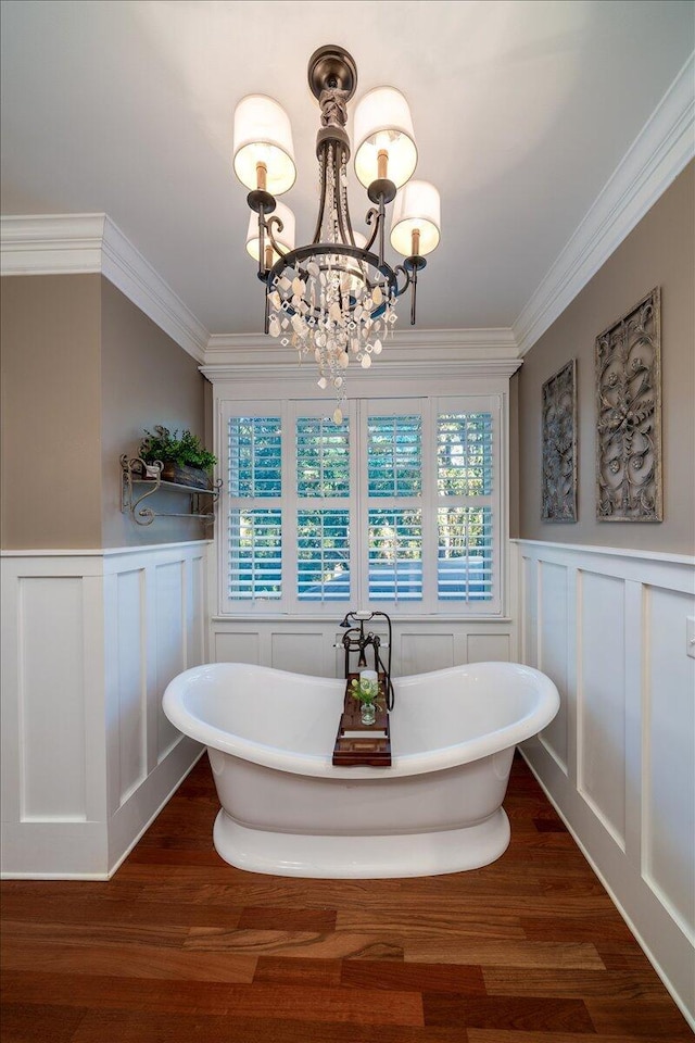 bathroom featuring crown molding, a bathtub, hardwood / wood-style floors, and an inviting chandelier