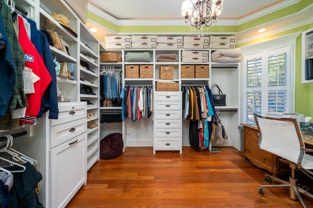 spacious closet featuring hardwood / wood-style flooring and an inviting chandelier