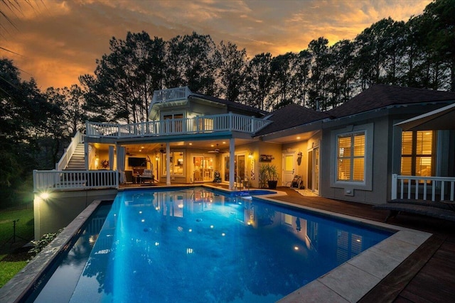 pool at dusk featuring a jacuzzi and ceiling fan