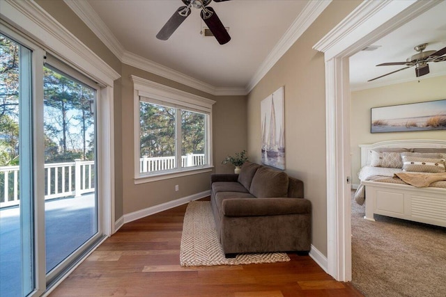 living area featuring ceiling fan, dark wood-type flooring, a healthy amount of sunlight, and ornamental molding