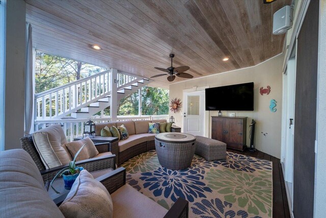 living room featuring ceiling fan and wooden ceiling