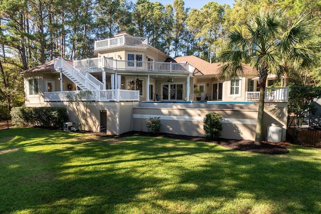 rear view of house with a lawn and ceiling fan