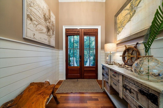 entryway featuring french doors, dark hardwood / wood-style floors, and wood walls