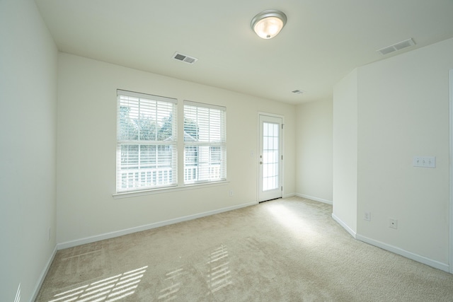 unfurnished room featuring light colored carpet