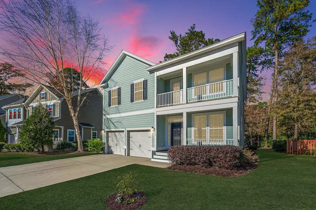 view of property with a yard, a garage, and a balcony