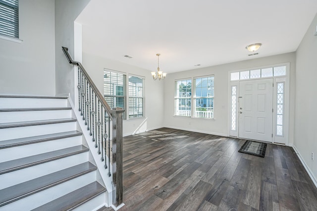 entrance foyer featuring dark hardwood / wood-style flooring and an inviting chandelier