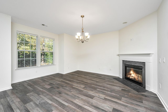 unfurnished living room with dark wood-type flooring and a chandelier