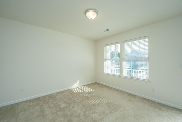 unfurnished room featuring light colored carpet