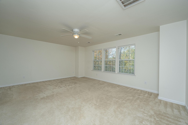 empty room featuring ceiling fan and light colored carpet