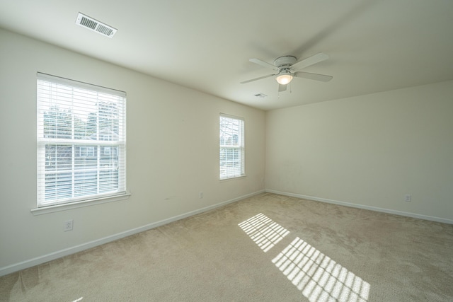 carpeted spare room with ceiling fan and a healthy amount of sunlight