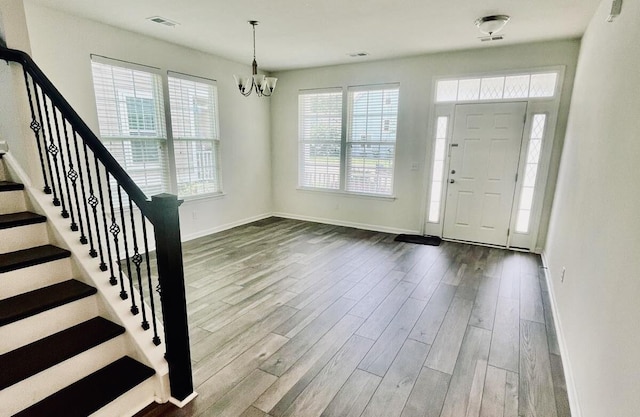 entryway with hardwood / wood-style floors and an inviting chandelier